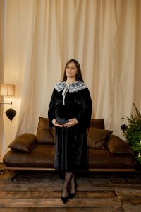 Rochia Nectaria din catifea neagră, cu guler detașabil din tulle brodat și mâneci clopot, potrivită și pentru femei însărcinate