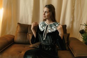 Rochia Nectaria din catifea neagră, cu guler detașabil din tulle brodat și mâneci clopot, potrivită și pentru femei însărcinate