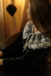 Rochia Nectaria din catifea neagră, cu guler detașabil din tulle brodat și mâneci clopot, potrivită și pentru femei însărcinate