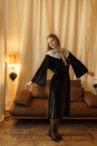 Rochia Nectaria din catifea neagră, cu guler detașabil din tulle brodat și mâneci clopot, potrivită și pentru femei însărcinate