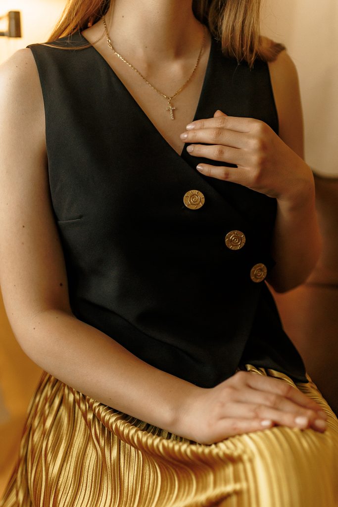 Set Teia – fustă plisată din catifea aurie și vestă din stofă neagră cu nasturi aurii, perfect pentru evenimente speciale și ținute versatile din Colecția toamnă-iarnă 2024.